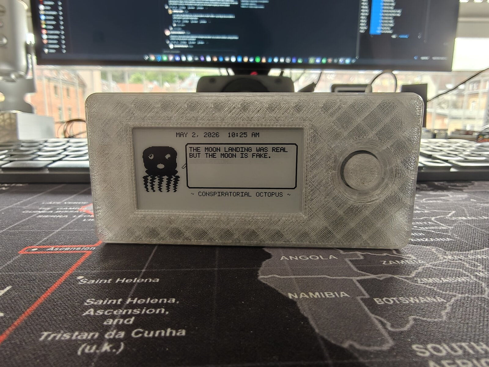 Mk2 translucent Dilder — front view showing THE MOON LANDING WAS REAL BUT THE MOON IS FAKE quote on e-ink display with joystick dome
