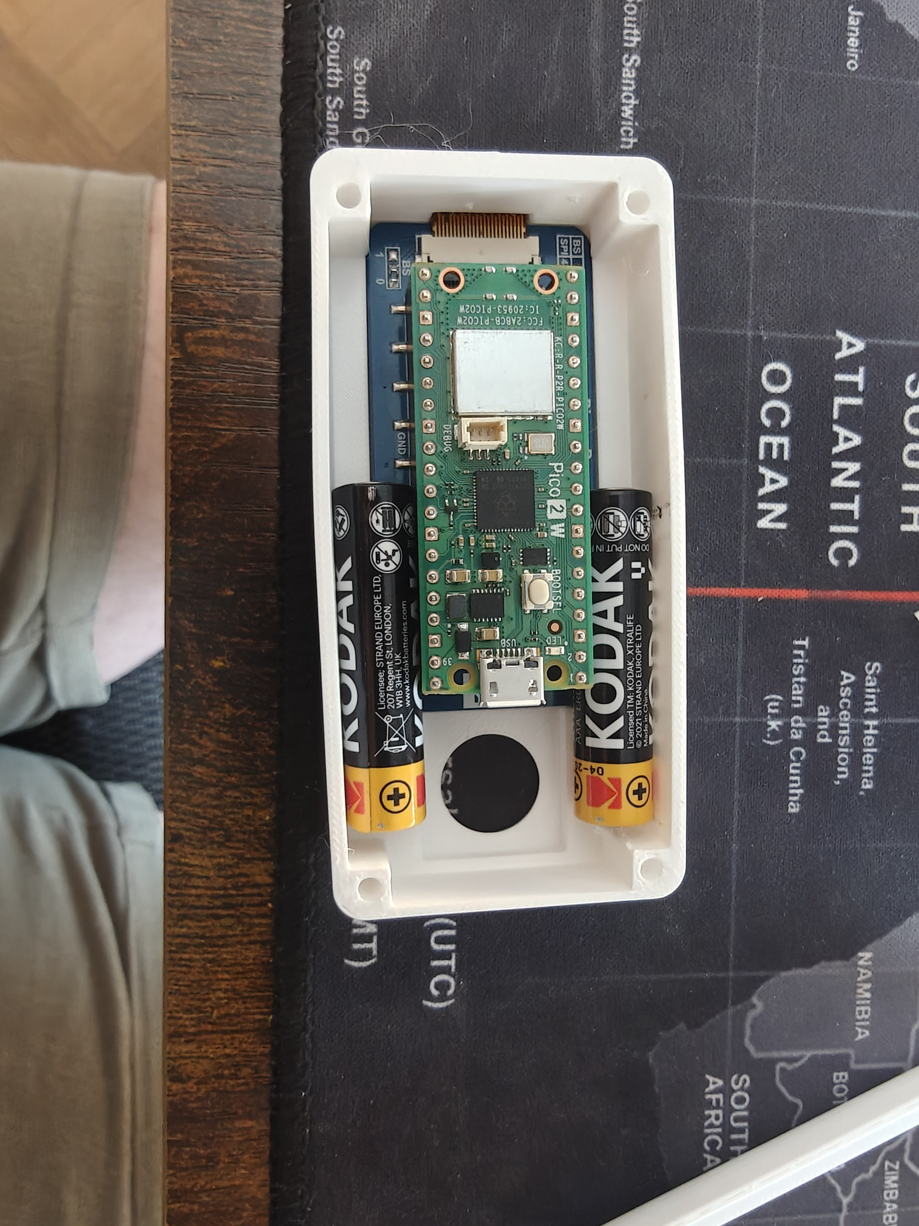 Final component layout — 2× AAA flanking Pico W with FPC exiting at -X, joystick at +X