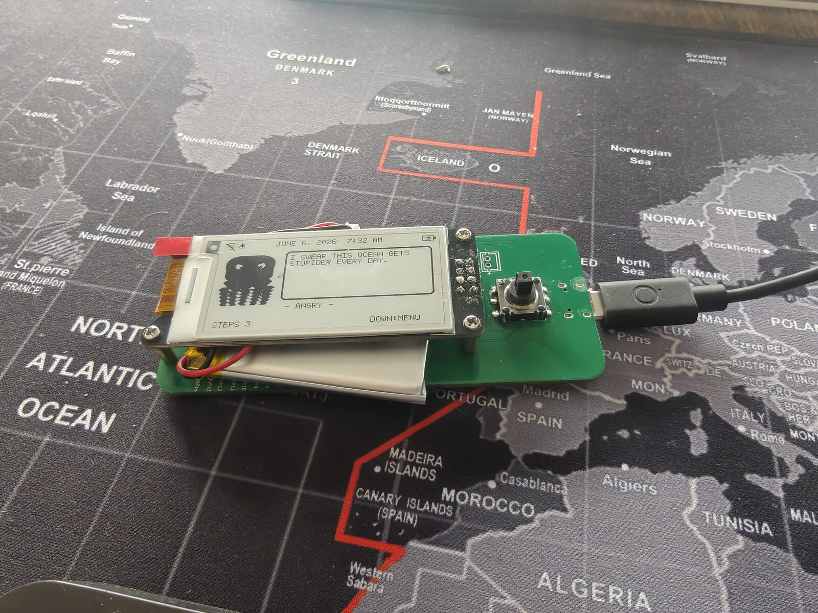 Dilder Board with joystick on a world map — wide layout showing "I SWEAR THIS OCEAN GETS STUPIDER EVERY DAY.", ANGRY mood, STEPS 3, and WiFi/Bluetooth/battery status icons