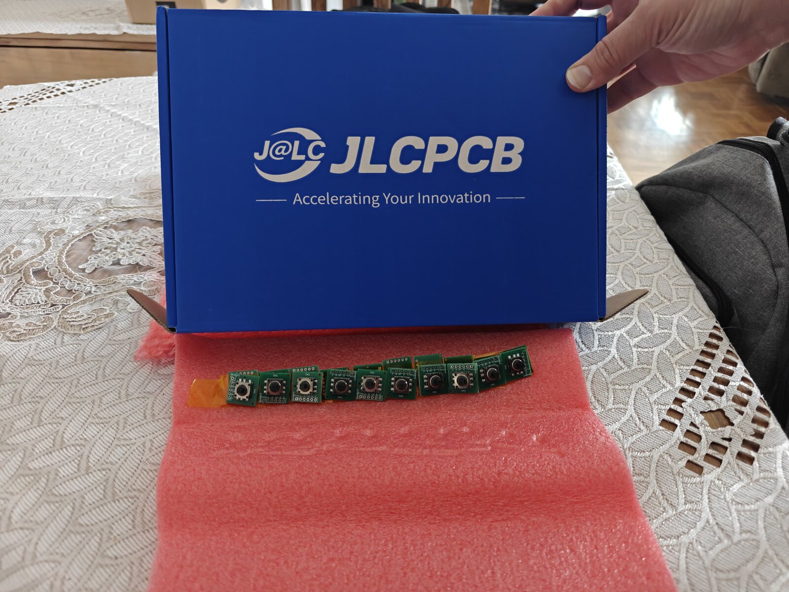 JLCPCB blue shipping box with full panel of joystick breakout boards on pink antistatic foam